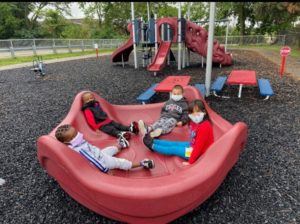 People Sitting on Playground Equipment